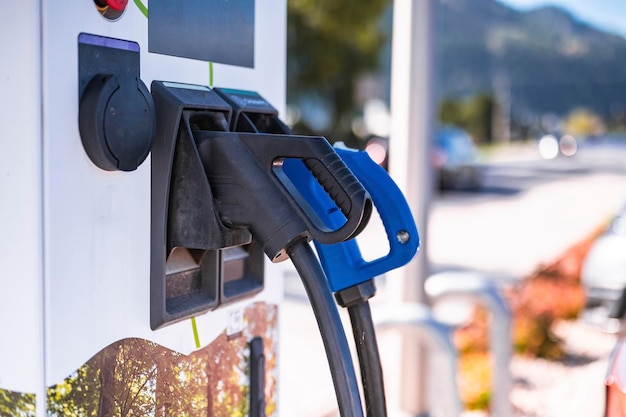 Ładowanie samochodu elektrycznego na parkingu ze stacją ładowania samochodów elektrycznych na ulicy miasta