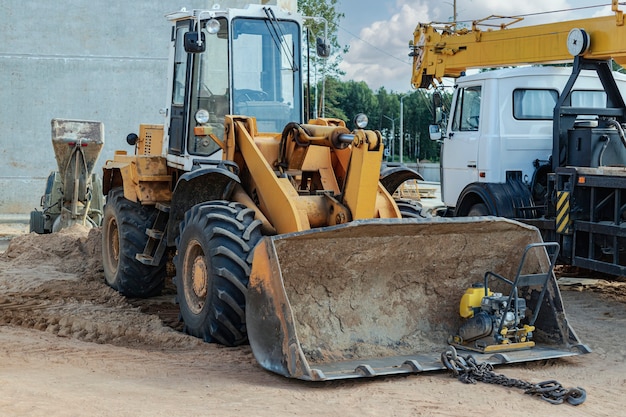 Ładowarka kołowa ciężka z łyżką na budowie. Sprzęt do robót ziemnych, transportu i załadunku materiałów sypkich - ziemia, piasek, tłuczeń kamienny.