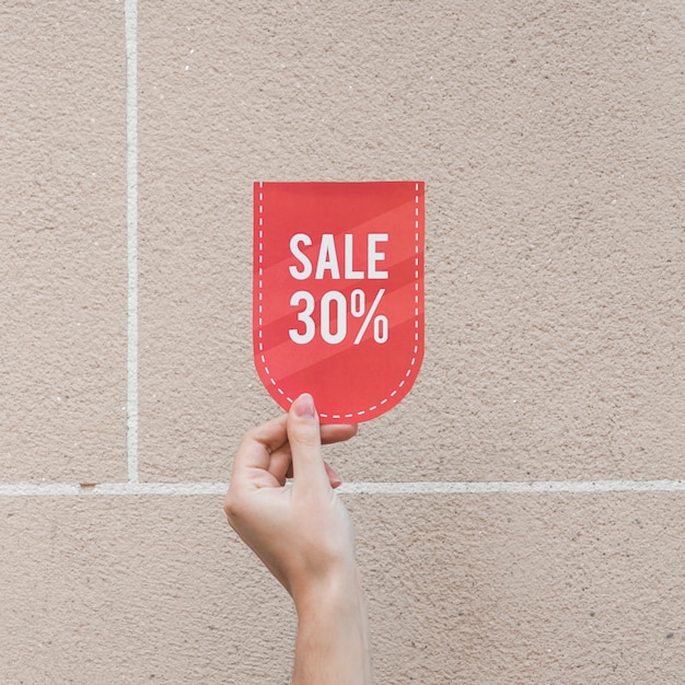 Zdjęcie lady's hand with red sale sign