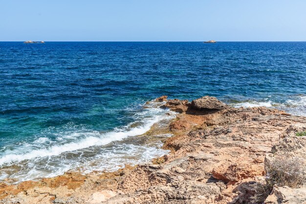 Łagodne wybrzeże wyspy Ibiza małe fale na powierzchni wody Baleary Hiszpania