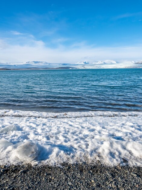 Laguna lodowcowa Jokulsarlon w sezonie zimowym z lodowcem i dużą górą lodową na Islandii