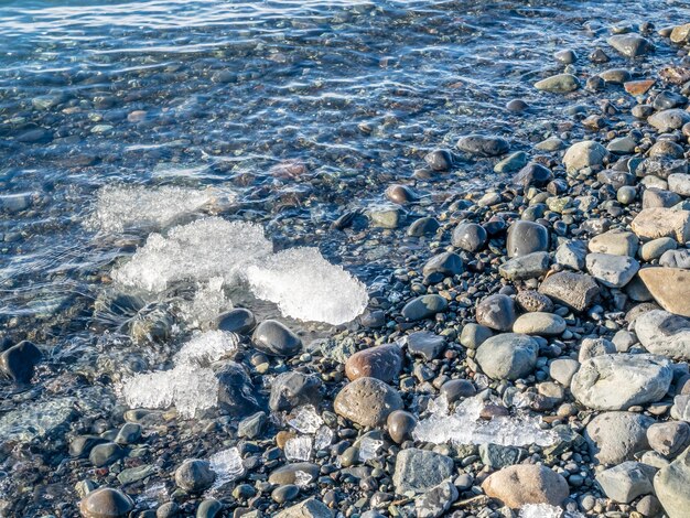 Laguna lodowcowa Jokulsarlon z lodowcem i dużą górą lodową pod zachmurzonym błękitnym niebem na Islandii