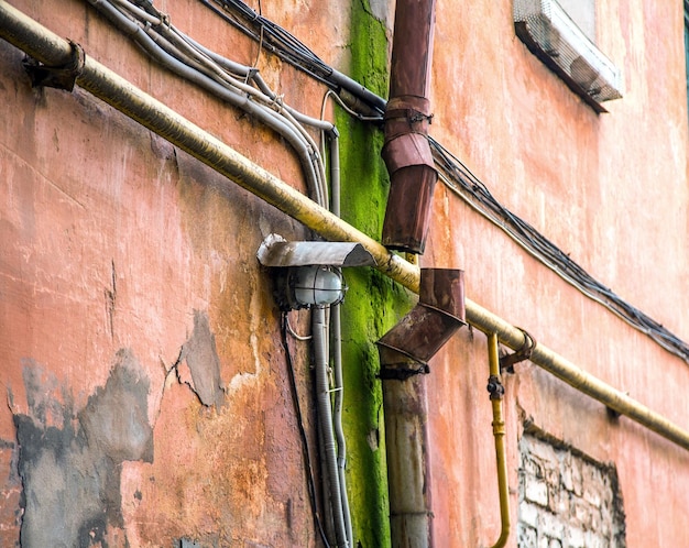 Lampa na starej ścianie w pobliżu zardzewiałej rynny