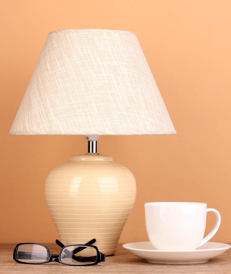 Zdjęcie lampa stołowa z kubkiem i szklankami na beżowym tle
