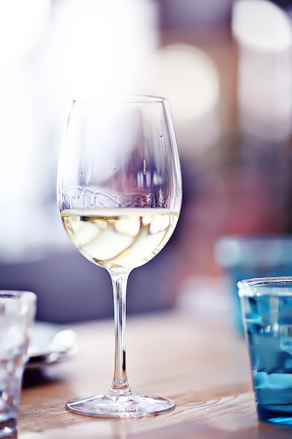 lampka białego wina w restauracji / białe wino we wnętrzu restauracji stół z lampkami wina, romantyczne lato