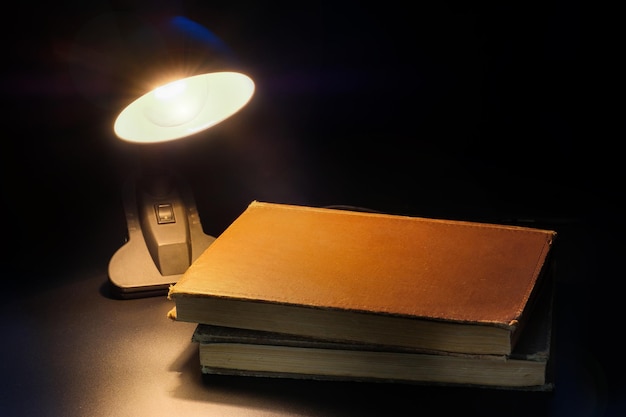 Lampowe oświetlenie książek na drewnianym stole Wnętrze sypialni w stylu retro