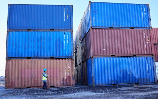 Łańcuch dostaw logistycznych i kobieta w porcie kontenerowym sprawdzająca listę zapasów dla globalnej firmy transportowej Inspektor żeńskiej stoczni przemysłowej liczy stos ładunków do dostawy w magazynie