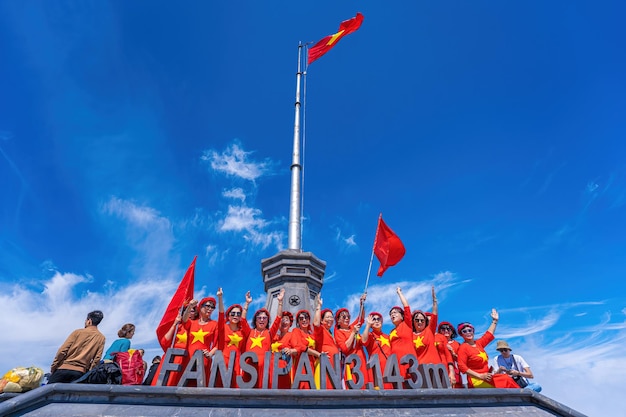Lao Cai Wietnam 12 marca 2023 Ludzie z flagami na szczycie góry Fansipanfansipan szczyt najwyższy szczyt Indochin prowincja sapa lao cai na północ od wietnamu