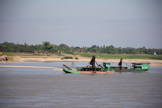 Laos ludzie pracujący z pogłębiarką ssącą piasku na brzegu rzeki Mekong w Nong Khai Tajlandia