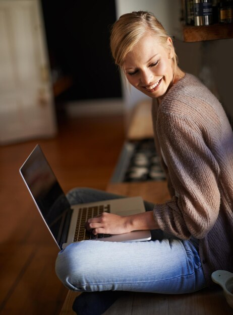 Zdjęcie laptop do pracy zdalnej i szczęśliwa kobieta w domu do planowania badań lub komunikacji internetowej uśmiech niezależny i kobieta w salonie z blogiem mediów społecznościowych lub projektem lub zadaniem copywritingowym