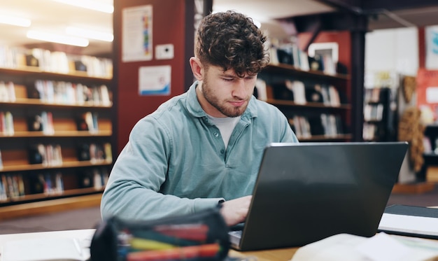 Laptop i badania z człowiekiem w bibliotece dla edukacji wiedzy i pracy dyplomowej Akademia przyszłość i uniwersytet z studentem i portal online dla projektu egzaminu i stypendium