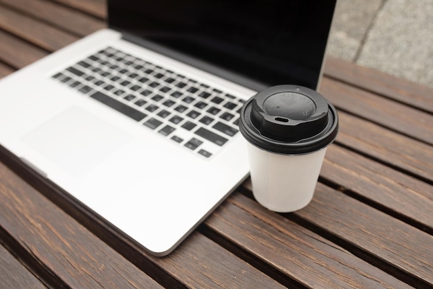 Zdjęcie laptop i kawa na drewnianym tle biuro na świeżym powietrzu