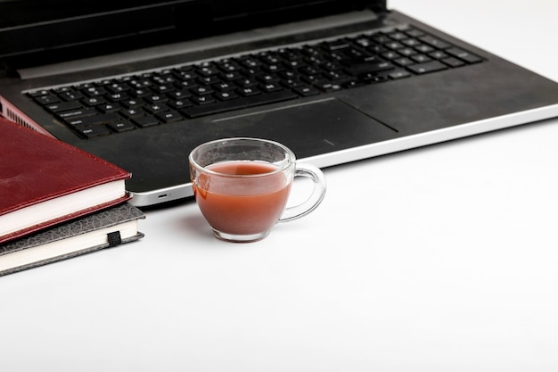Zdjęcie laptop i pamiętnik z filiżanką herbaty