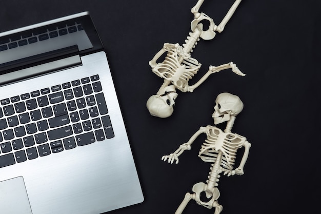 Laptop I Szkielety Na Czarnym Tle. Motyw Halloween. Widok Z Góry