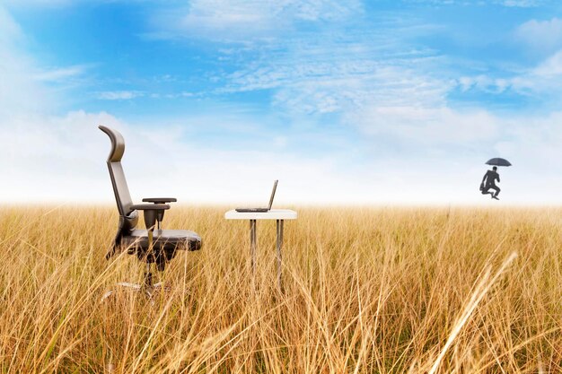 Zdjęcie laptop siedzi w wysokiej trawie na polu