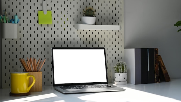 Laptop uchwyt na ołówek filiżanka kawy i roślina doniczkowa na białym stole Pusty ekran dla wiadomości tekstowych lub treści informacyjnych