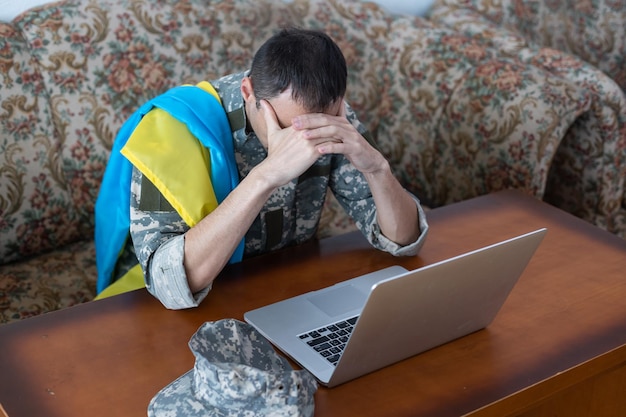 Laptop, wiadomość dla pokoju na świecie. wojsko z laptopem i flagą ukrainy. wojskowa konferencja online