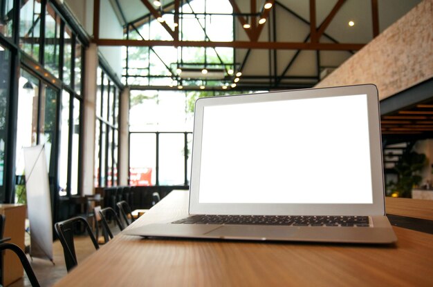 Laptop z Mock up pustym ekranem na drewnianym stole przed kawiarnią przestrzeń dla tekstu wyświetlacz produktu komputer laptop technologia montażu praca niezależna