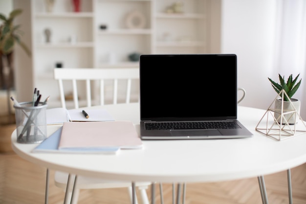Zdjęcie laptop z pustym ekranem stojący na stole w domu