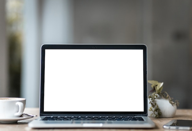 laptop z pustym ekranem z filiżanką kawy i smartfonem na stole