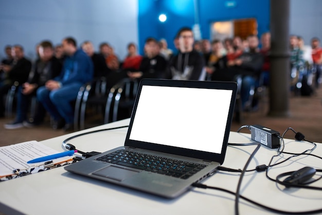 Zdjęcie laptop z pustym ekranem z zamazanymi ludźmi na tle