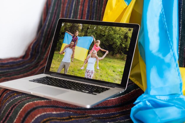 laptop z wideokonferencją w pobliżu flagi ukrainy.