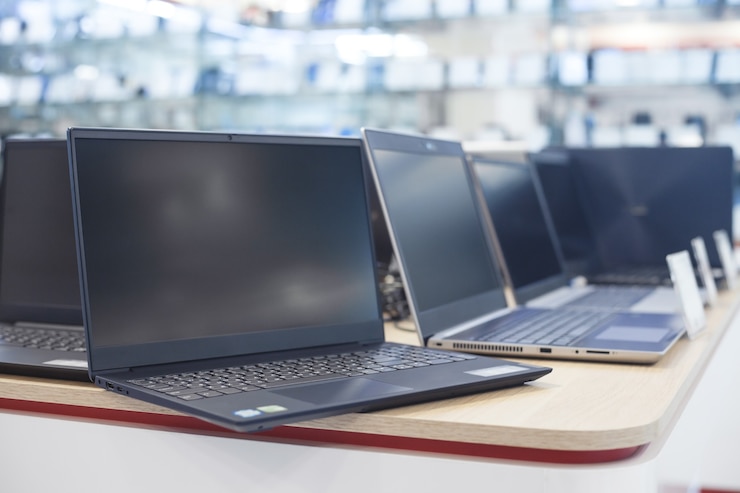Laptopy na stole w sklepie elektronicznym.