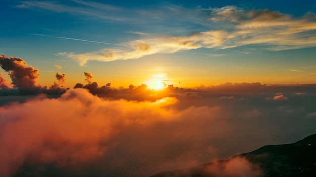 Zdjęcie latając w jasnych chmurach nad morzem w jasnych kolorach zachodu słońca