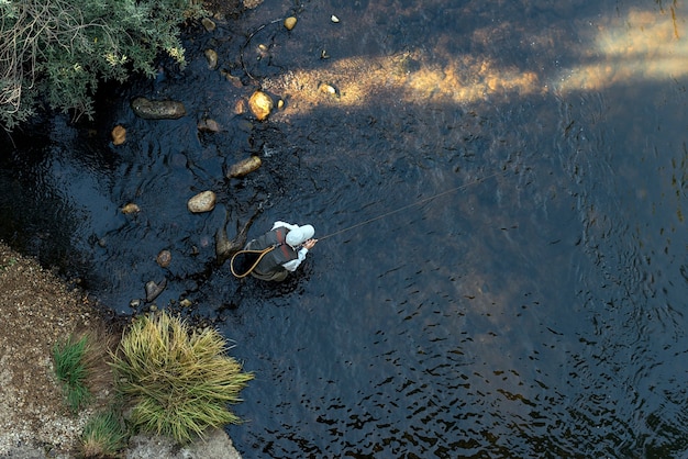 Latający rybak używający wędki muchowej w pięknej rzece