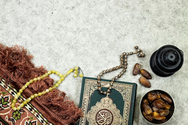 Zdjęcie latarnia i święty koran z arabską kaligrafią znaczenie al quran i mat modlitewny różaniec muzułmanin