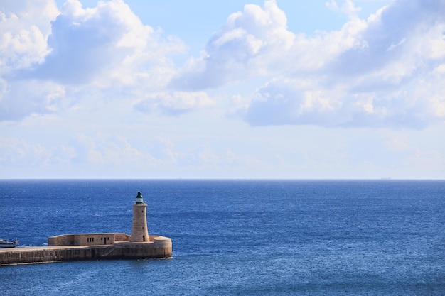 Latarnia morska St Elmo w Valletcie Malta Falochron wielkiego portu między niebieskim tle morza i nieba