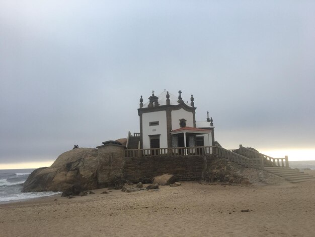 Zdjęcie latarnia na plaży nad morzem na tle nieba