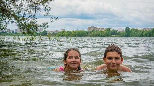 Zdjęcie latem brat i siostra kąpią się w rzece