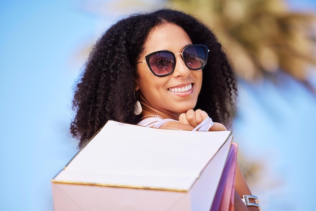 Lato wolności i dziewczyna z portretem torby na zakupy i uśmiechem w słonecznym Los Angeles USA Szczęśliwy konsumpcjonizm i modna czarna kobieta fashionistka z torbami detalicznymi dla stylowego stylu życia