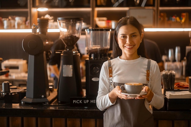 Latte art w dłoni baristy gotowy do picia w nowoczesnej kawiarni