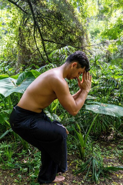Latynoamerykański mężczyzna robi joga postawa joga postawa Pszczoła do tyłu Prsthatah Brahmara forest