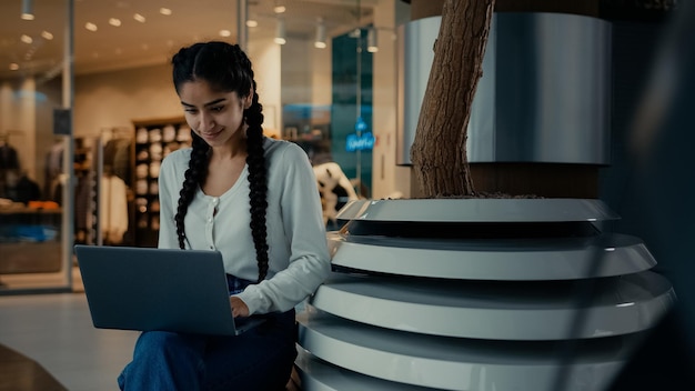 Latynoska biznesmenka, studentka, pracująca na laptopie w centrum handlowym, robiąca zamówienie online