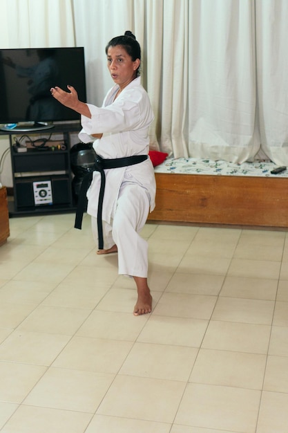 Zdjęcie latynoska kobieta trenuje kotlety karate w domu