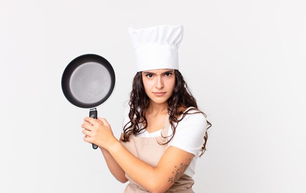 Latynoska ładna kucharz kobieta trzyma patelnię