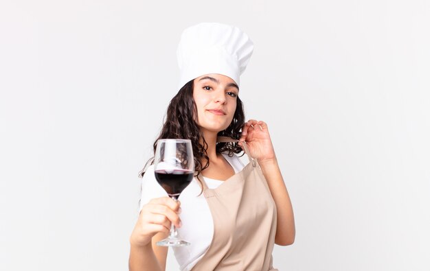 Latynoska ładna szefowa kuchni trzymająca kieliszek wina