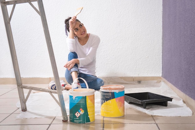 Latynoska malująca swój nowy dom jest szczęśliwa pracując