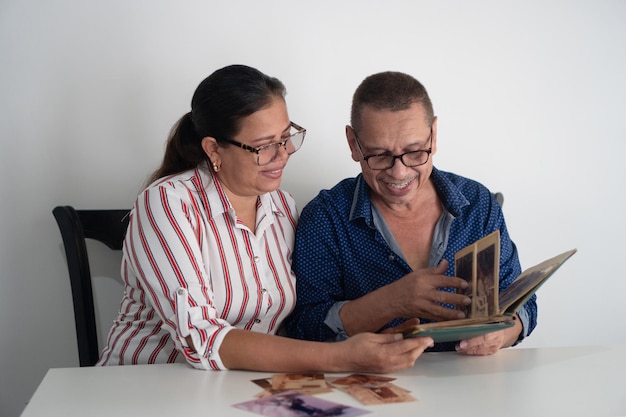 Latynoska para ogląda album ze zdjęciami w swoim domu