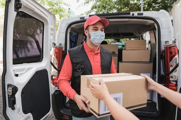 Latynoska przesyłka kurierska do klienta podczas noszenia maski ochronnej na wypadek epidemii koronawirusa