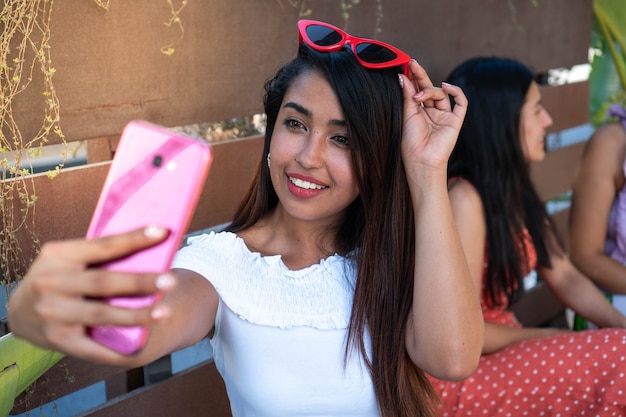 Latynoska robi selfie w mediach społecznościowych, spędzając popołudnie z przyjaciółmi