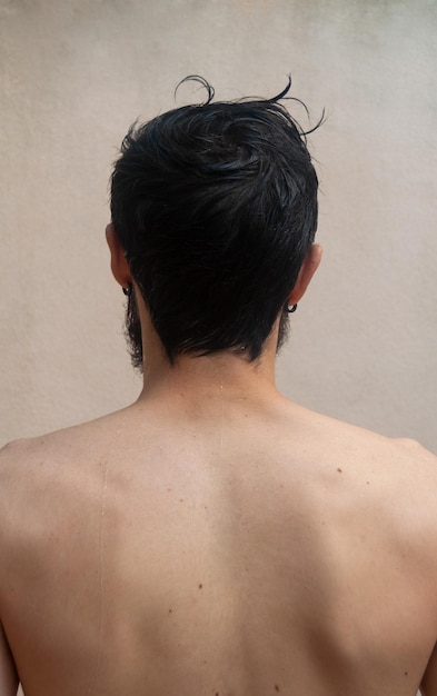 Zdjęcie latynoski młody człowiek z powrotem na ramionach myjący włosy