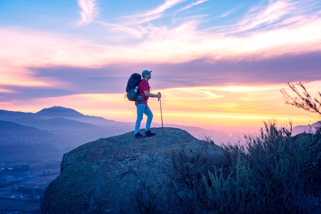 latynoski turysta na szczycie góry podczas zachodu słońca