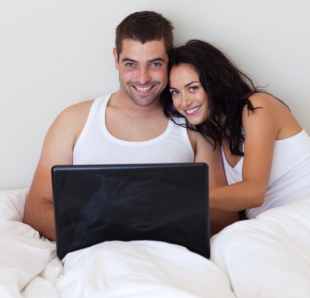 Laughing para za pomocą laptopa w sypialni