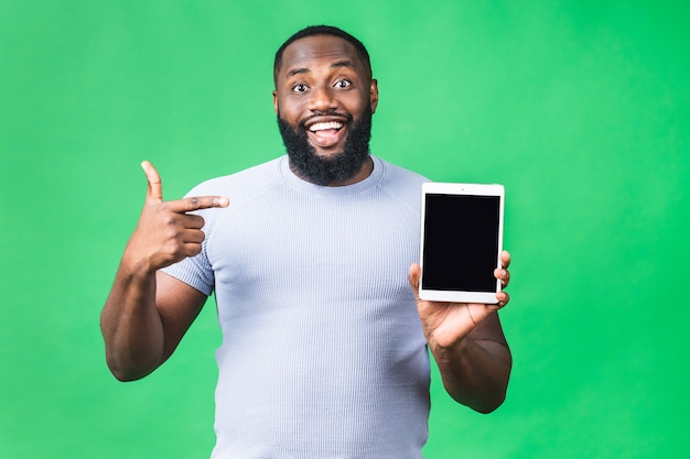 Laughing Young African American czarny mężczyzna trzyma komputer typu Tablet z panelem dotykowym na izolowanych na zielonym tle.