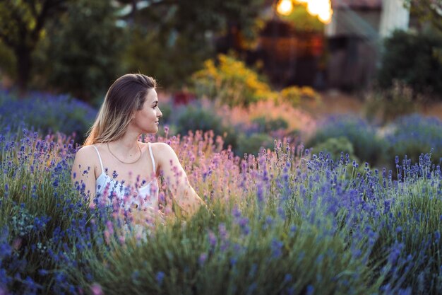 Lavender Garden Girl siedzi wieczorem i patrzy na boki i oddycha świeżym powietrzem