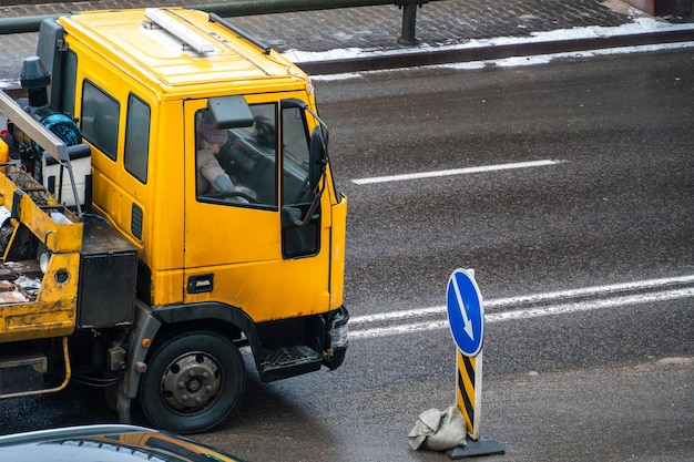 Laweta na drodze z zepsutym samochodem na przyczepie Wypadek na drodze w mieście Ewakuacja zepsutego samochodu po wypadku